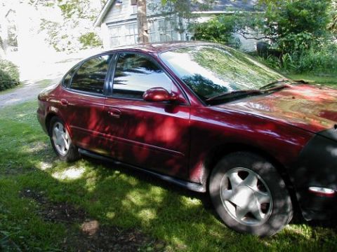1997 Ford Taurus - This 1997 Ford Taurus is seen from a 3/4 front angle, parked on a grassy area next to a house.