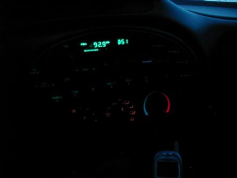 1997 Ford Taurus - The car's dashboard lights up at night, showing the radio display and climate controls.