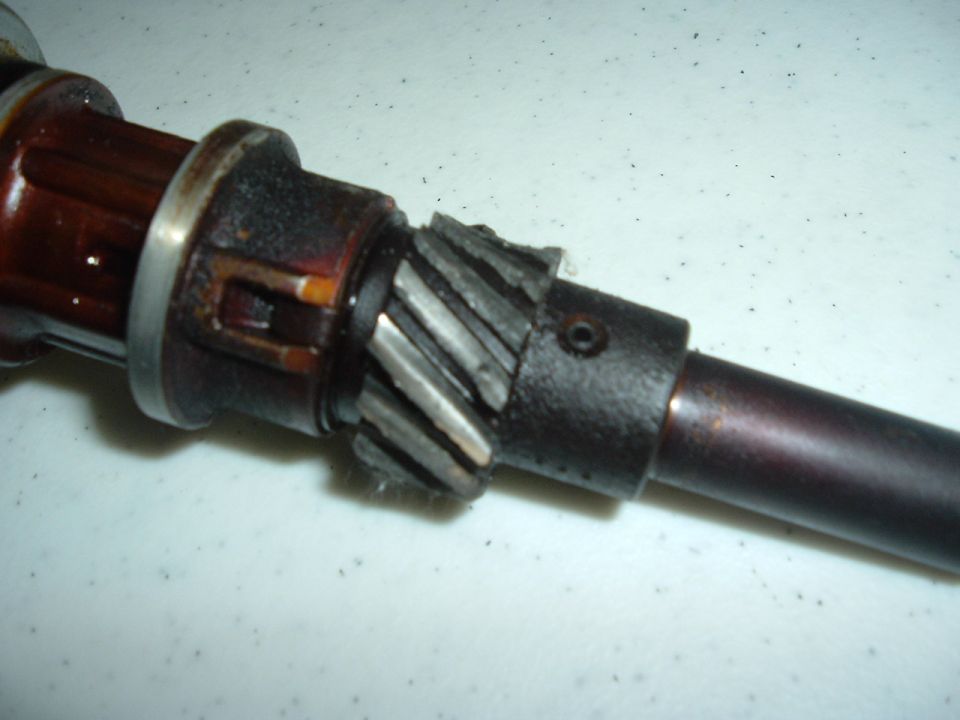 Close-up of a worn distributor gear with chipped teeth