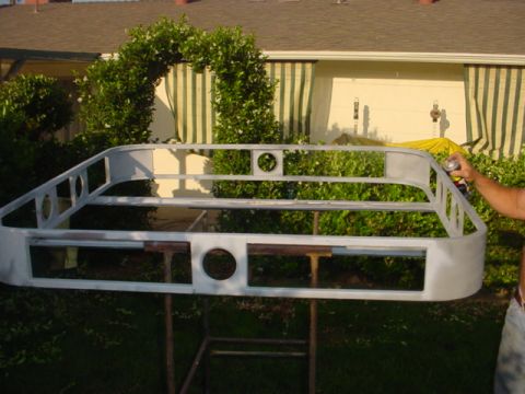 1988 Ford Bronco - A roof rack frame, possibly for an SUV, is being prepped for painting outdoors.