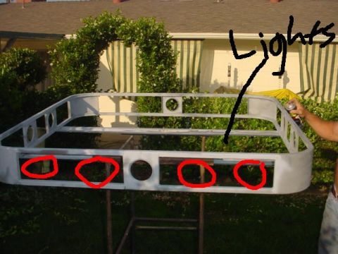 1988 Ford Bronco - A person is spray painting a roof rack frame that is mounted on a stand outdoors.