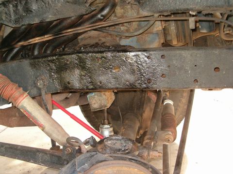 1979 Ford Bronco - Undercarriage view shows suspension components and frame, with visible rust and oil accumulation.