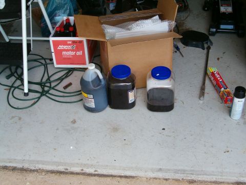 1979 Ford Bronco - Motor oil and containers are laid out on a concrete surface, possibly for an oil change.
