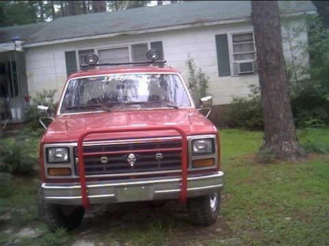 1985 Ford Bronco - This red Ford Bronco is equipped with a front bull bar and auxiliary lights on the roof rack.