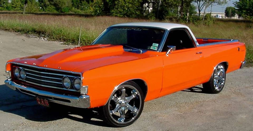 Orange 1969 Ford Ranchero with white roof and chrome wheels, front 3/4 view