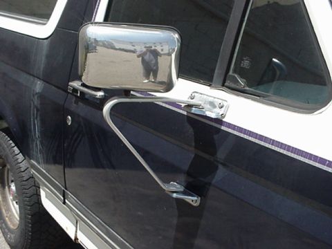 1989 Ford Bronco - The side mirror and door of a two-tone Ford Bronco are shown, with a reflection of the photographer in the mirror.