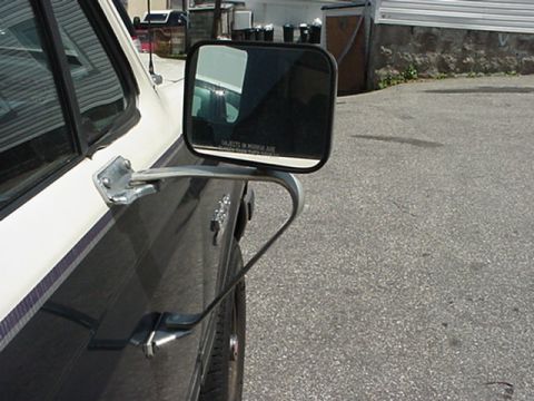 1989 Ford Bronco - Side view of a Ford Bronco's mirror and door panel, showing a two-tone paint scheme with a purple stripe.