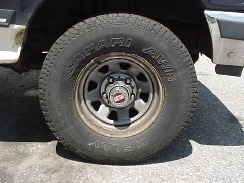 1989 Ford Bronco - A close-up view of a Kelly Safari AWR tire mounted on a vehicle's wheel, with the Supermotors.net logo visible at the bottom right.
