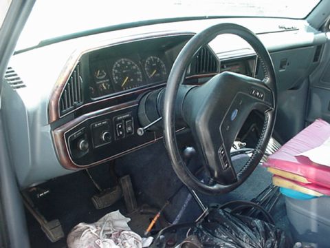 1989 Ford Bronco - The interior of a 1989 Ford Bronco, its dashboard, steering wheel, and pedals.
