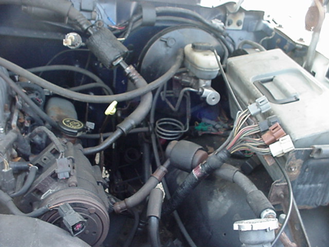 Engine bay with brake master cylinder, vacuum lines, and wiring harness