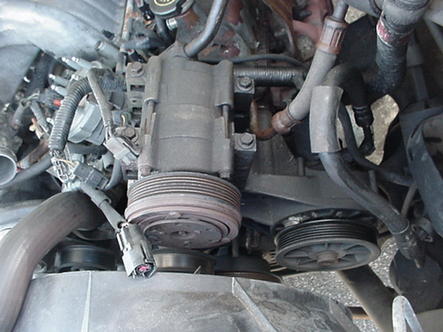 Engine bay air conditioning compressor and pulleys