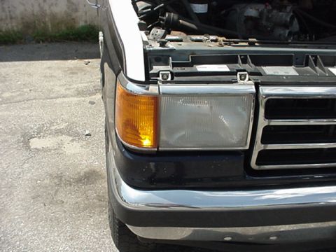 1989 Ford Bronco - Front view of a dark blue Ford Bronco with its hood open, revealing the engine compartment.