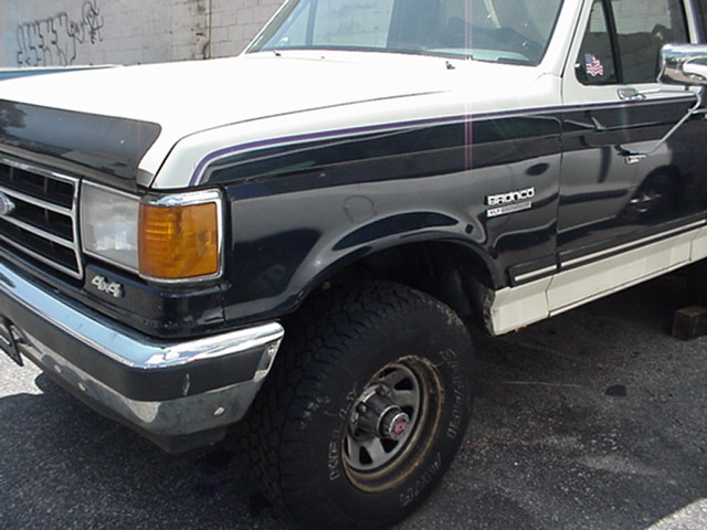Black and white Ford Bronco, front quarter view, showing "4x4" badge and "BRONCO" emblem
