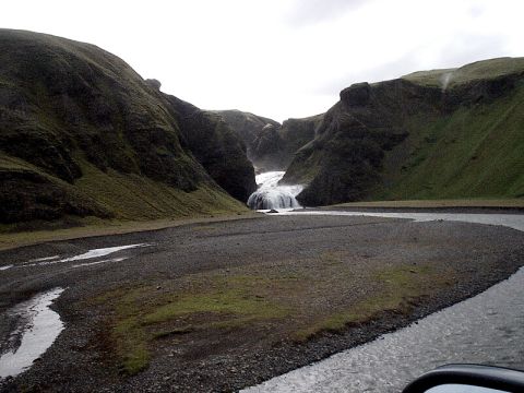 1996 Ford Bronco - A view of a waterfall in a canyon, seen from the side mirror of a vehicle.