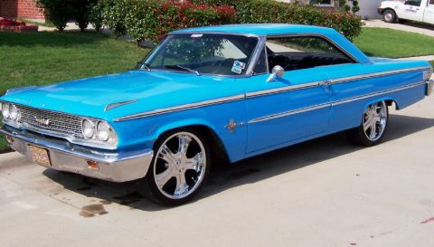 1963 Ford Galaxie - A bright blue 1963 Ford Galaxie is shown from a three-quarter front angle, custom chrome wheels.
