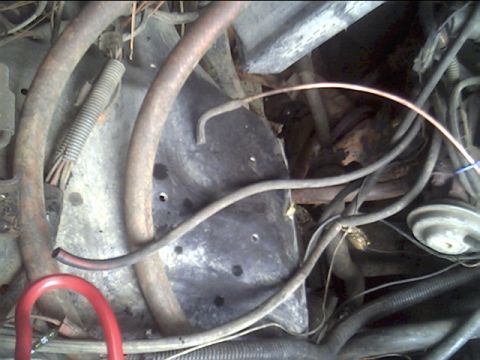 1985 Ford Bronco - Close-up view of a cluttered engine bay with various hoses and wiring harnesses.