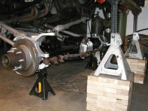 1994 Ford Bronco - Close-up of vehicle front suspension and steering parts supported by jack stands.