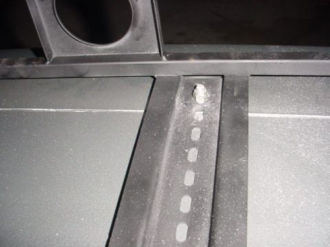 1988 Ford Bronco - This image shows a close-up view of a metal bracket, likely for a roof rack, with visible mounting hardware.