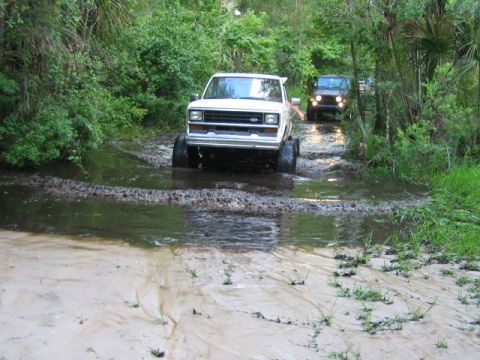 1992 Ford Bronco - A 1992 Ford Bronco navigates a muddy water crossing, with a Jeep in tow.