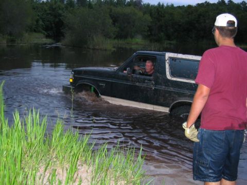 1992 Ford Bronco - A 1992 Ford Bronco is driven through a body of water, kicking up spray.
