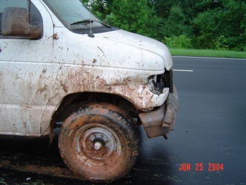 1986 Ford Bronco - Van covered in mud after an apparent accident, showing damage to the front.