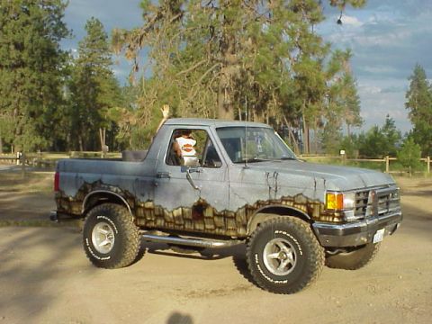 1989 Ford Bronco - This 1980s Ford Bronco features a unique paint job resembling wood grain and cracked surfaces, seen here from a 3q-front angle.