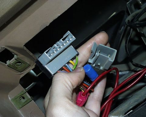 1988 Ford E250 - Close-up of automotive wiring harness connectors being handled.