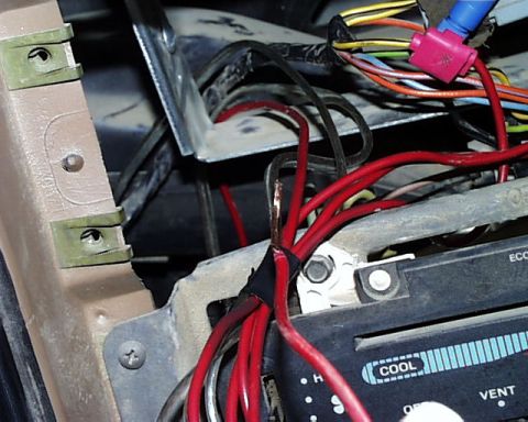 1988 Ford E250 - A close-up view of exposed wiring and electrical components within a vehicle's dashboard area.