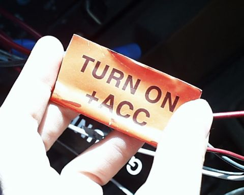 1988 Ford E250 - A label reads 'TURN ON + ACC' and is held by a hand near some wires.