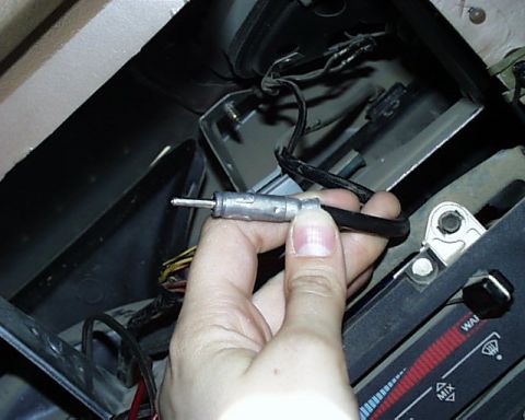 1988 Ford E250 - A hand holds a car antenna connector near dashboard controls, with visible text labels.