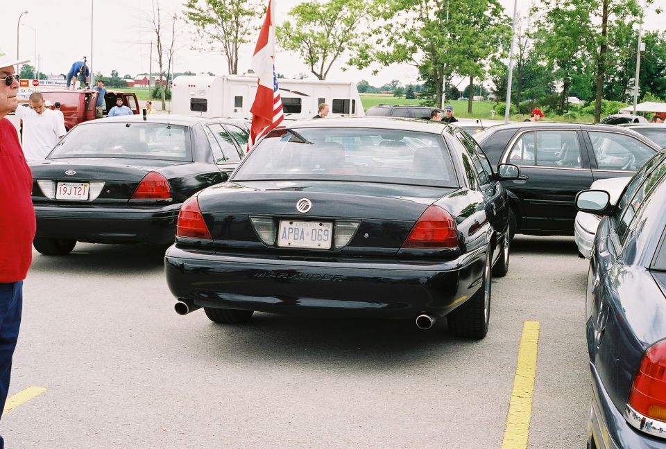 Rear view of a black 1998 Ford Crown Victoria police car parked in a lot, license plate APBA-069