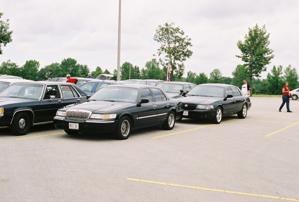 1998 Ford Crown Victoria and another black sedan parked in a lot