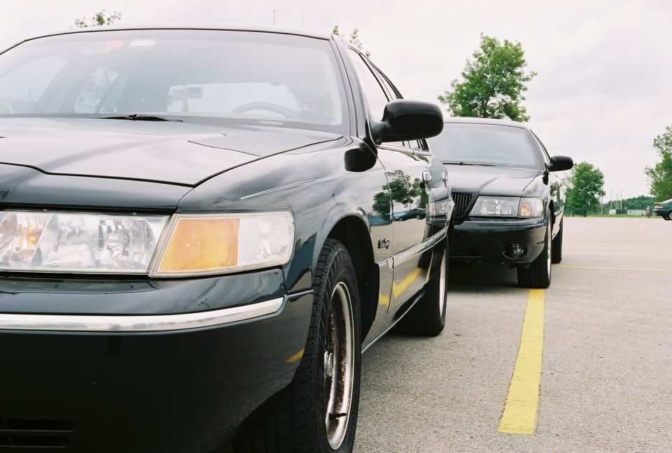 1998 Ford Crown Victoria parked next to another black sedan