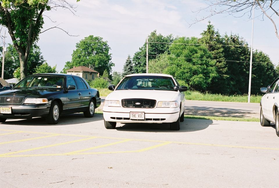White 1998 Ford Crown Victoria front view with custom license plate "THE VIC"