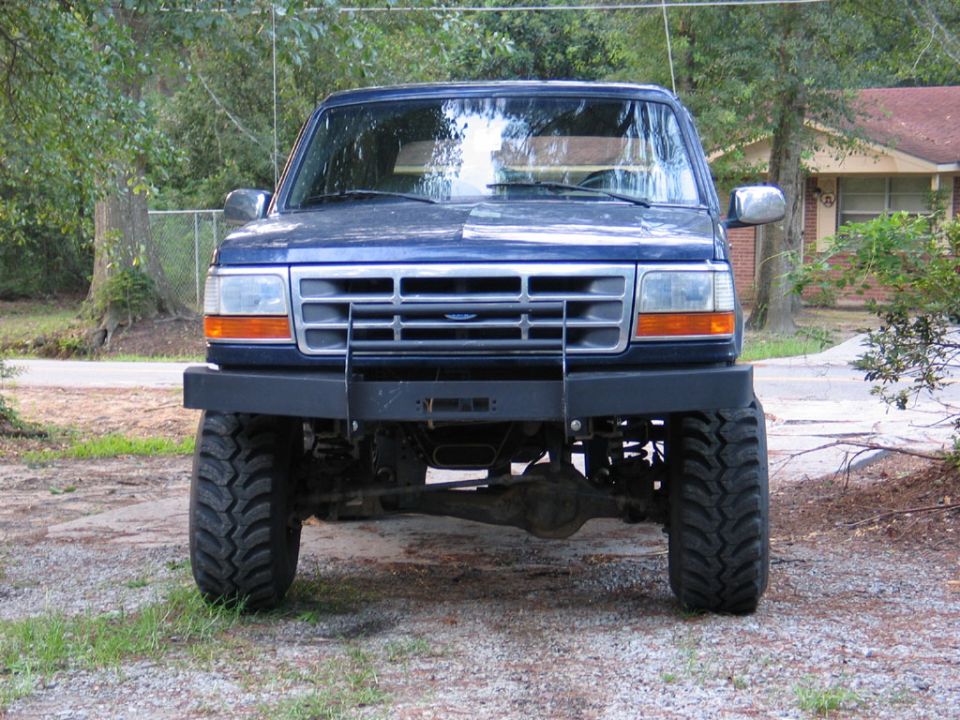 Blue Ford Bronco front view, lifted with large tires and aftermarket bumper