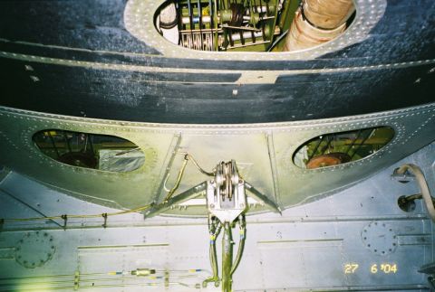 1988 Ford Bronco - Looking up into the complex internal structure of an aircraft, revealing its mechanical systems and riveted panels.