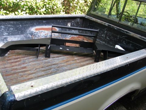 1995 Ford Bronco - An aftermarket bumper and brush guard are stored in the bed of a pickup truck.