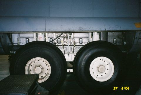 1988 Ford Bronco - Close-up view of the landing gear assembly on an aircraft, showing large tires and mechanical parts.