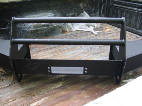 1995 Ford Bronco - Black metal grille guard with two horizontal bars and mounting holes, resting in a truck bed.