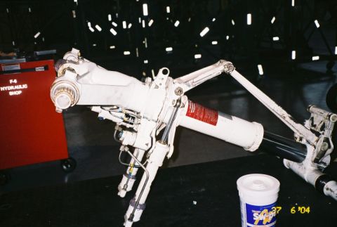 1988 Ford Bronco - Close-up of an aircraft landing gear strut assembly, with a toolbox in the background.
