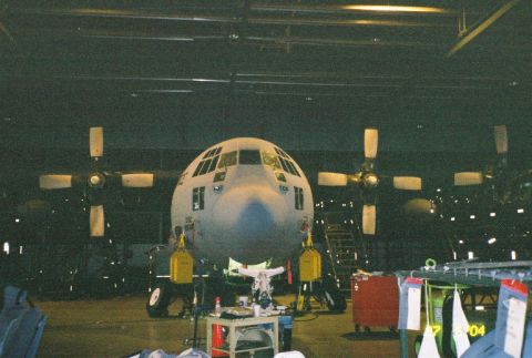 1988 Ford Bronco - A Lockheed C-130 Hercules aircraft is parked inside a hangar, viewed from the front.