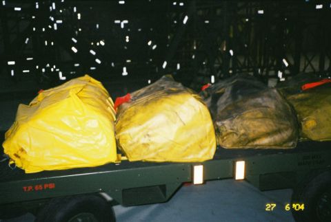 1988 Ford Bronco - Several large, covered bags are loaded onto a trailer, with visible text indicating tire pressure.