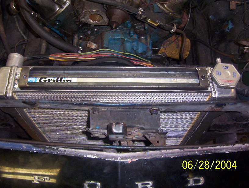 Aluminum Griffin radiator and CST cap installed ahead of a blue engine in a Ford engine bay