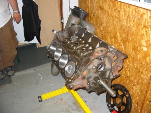 1995 Ford F-150 - Engine block displayed on a yellow stand, with visible cylinders and crankshaft, suggesting a disassembled engine.