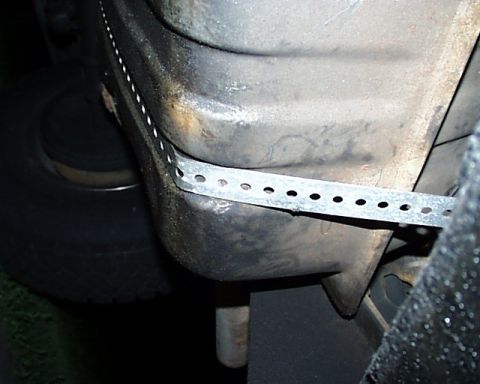 1988 Ford C-350 (Centurion Conversions) - Close-up view of the undercarriage of a vehicle, showing a metal strap secured to the frame.