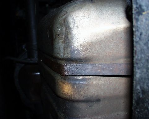 1988 Ford C-350 (Centurion Conversions) - Close-up view of a corroded exhaust pipe connection, showing signs of wear and tear.