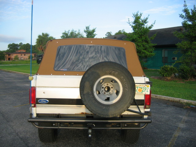 Rear of tan/cream Ford Bronco SUV with spare tire, tube bumper and Florida plate