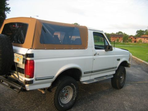 1992 Ford Bronco - This 1992 Ford Bronco features a removable tan soft top and a rear-mounted spare tire.