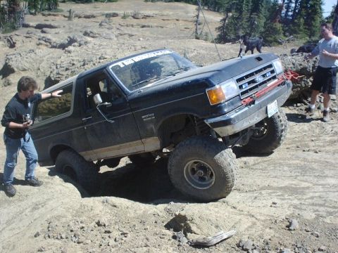 1978 Ford Bronco - This lifted Ford Bronco is tackling a challenging off-road course with steep inclines and loose terrain.