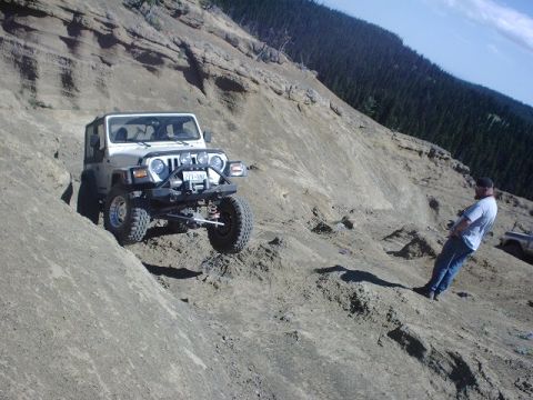 1978 Ford Bronco - Jeep Wrangler tackling a challenging off-road trail on a sunny day.